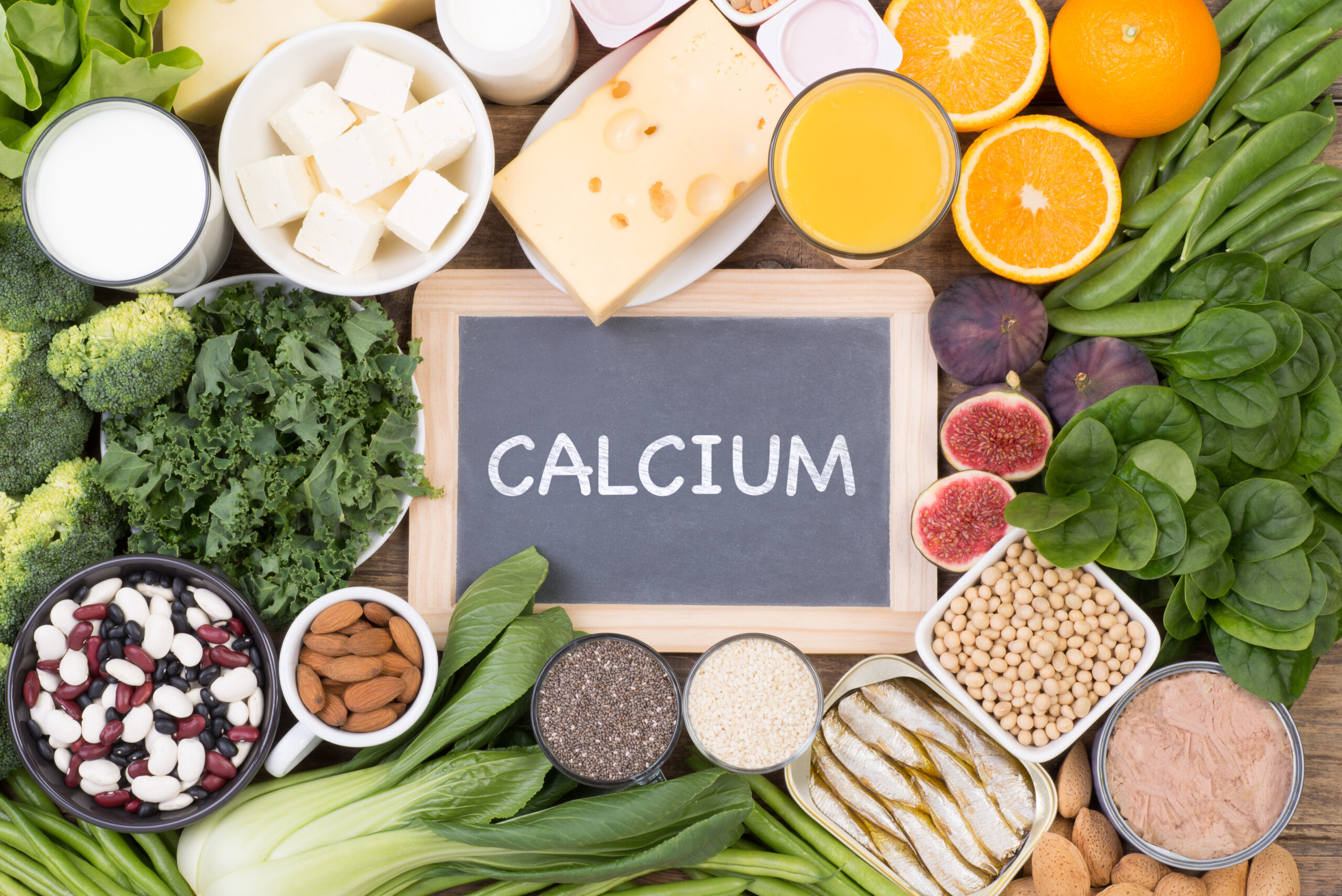 A slate with "Calcium" written on it surrounded by calcium rich foods